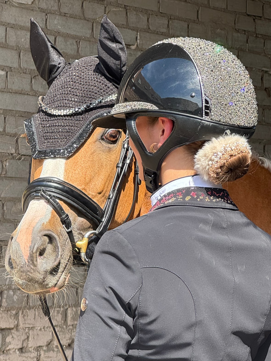 Rider in a glittering helmet with a fur-trimmed BelliNoxx bun, leaning against a pony
