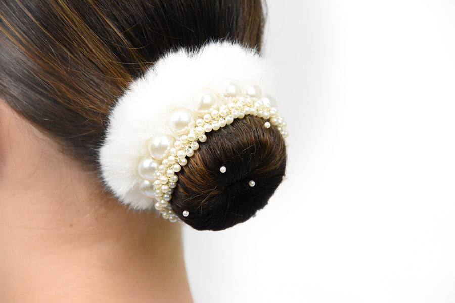 Finished bun with white faux fur, a pearl accessory and a pearl hairnet